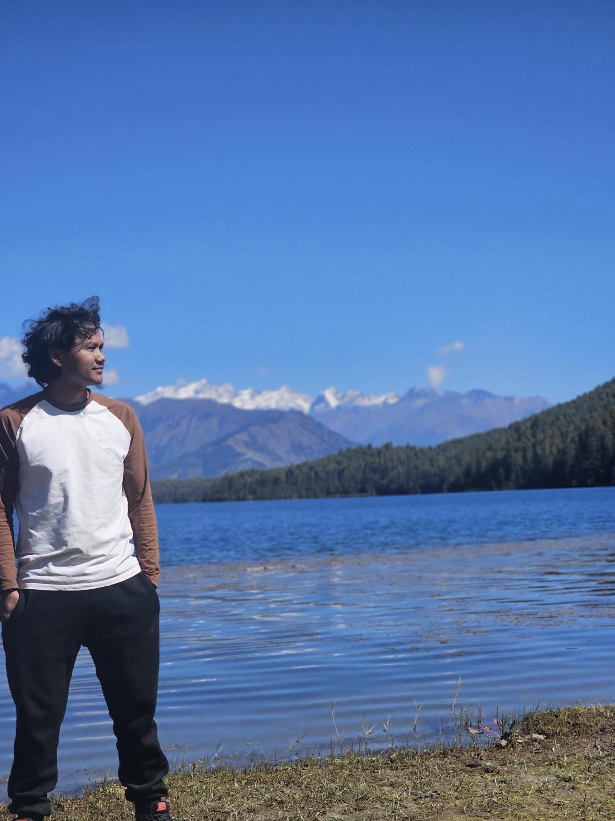 Gagan jumping by the crystal blue water of Rara Lake